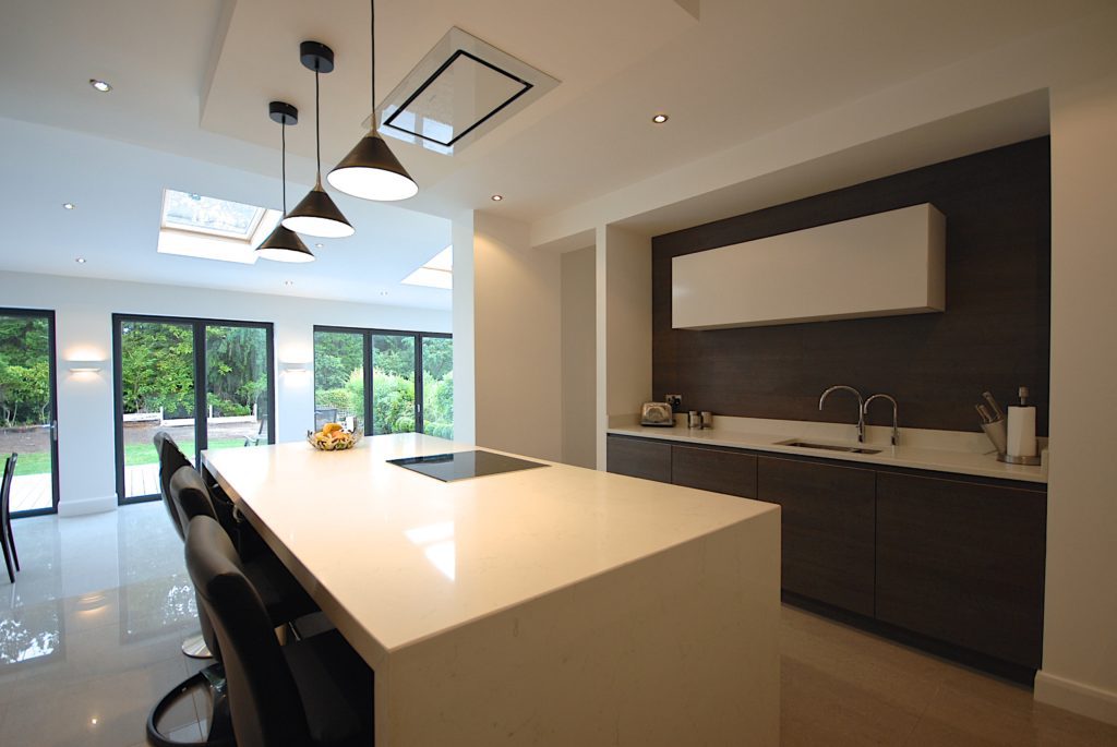 a modern kitchen with a large kitchen island and bar stools.