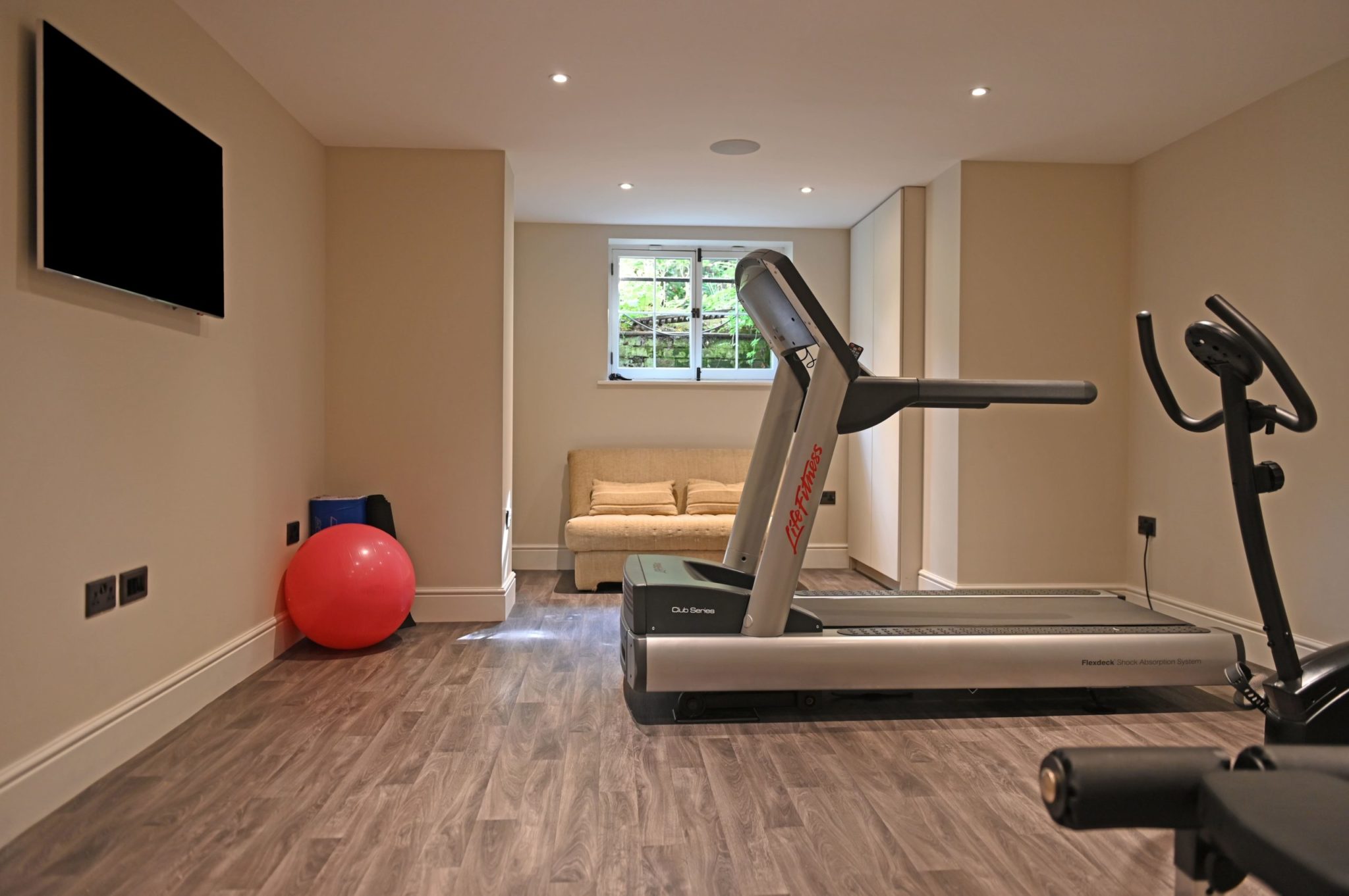 a room with a treadmill and a red ball.
