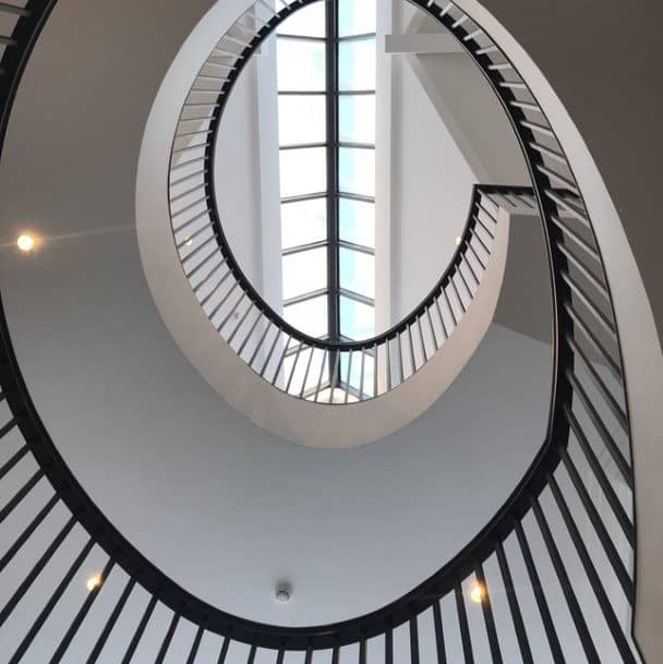 a spiral staircase in a building with a skylight.