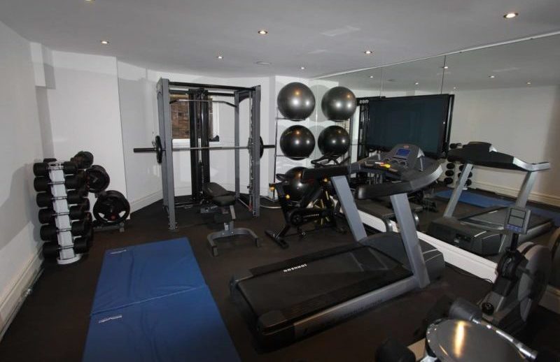 a home gym with a treadmill and exercise equipment.