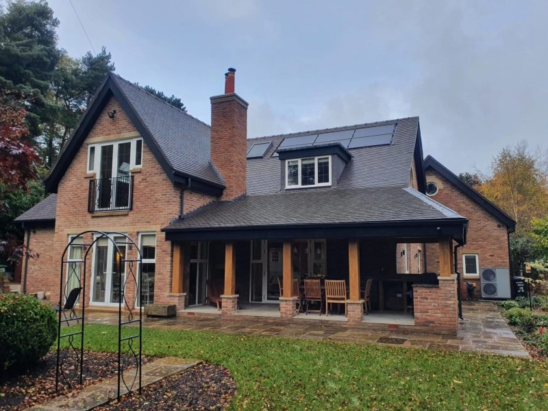 a large brick house with a black roof.