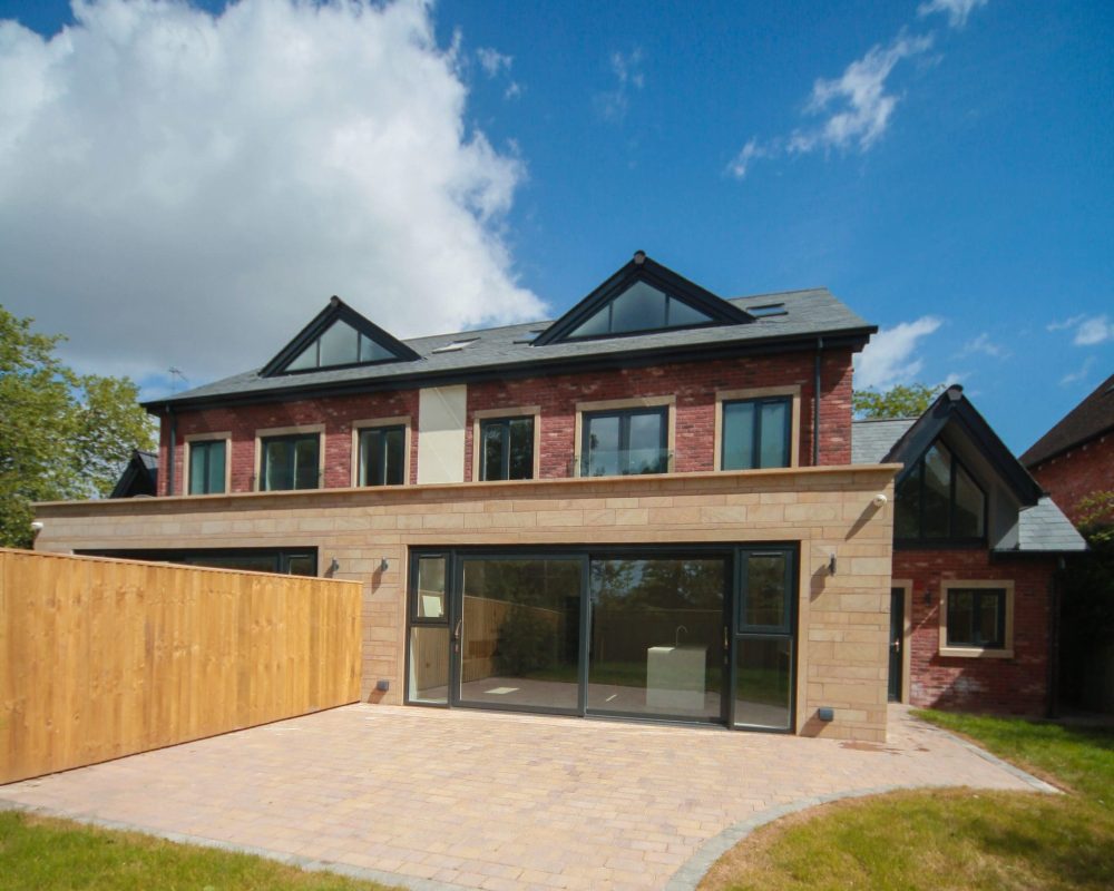 a large brick house with a wooden fence.