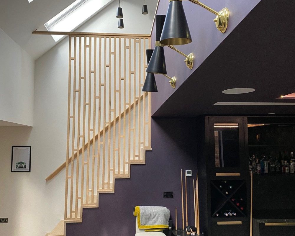 a pool table in a room with a stair case.