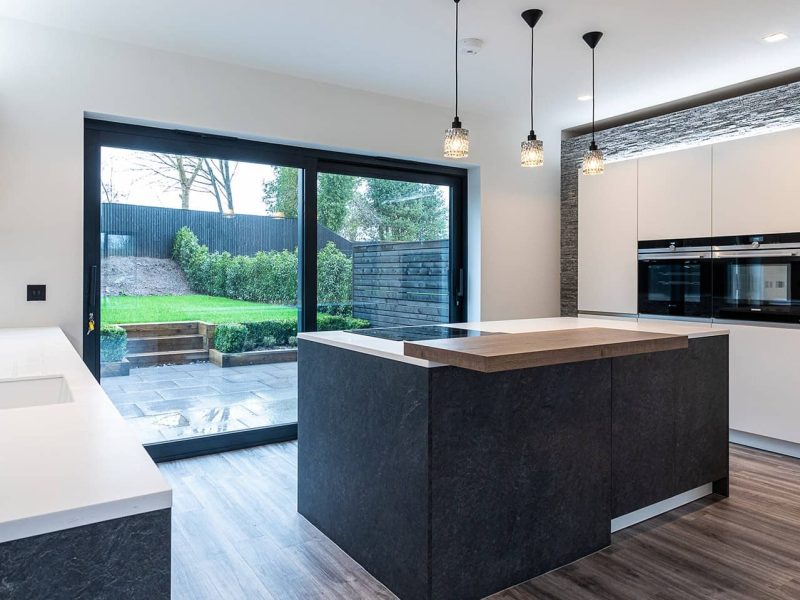 a modern kitchen with a large window overlooking the backyard.